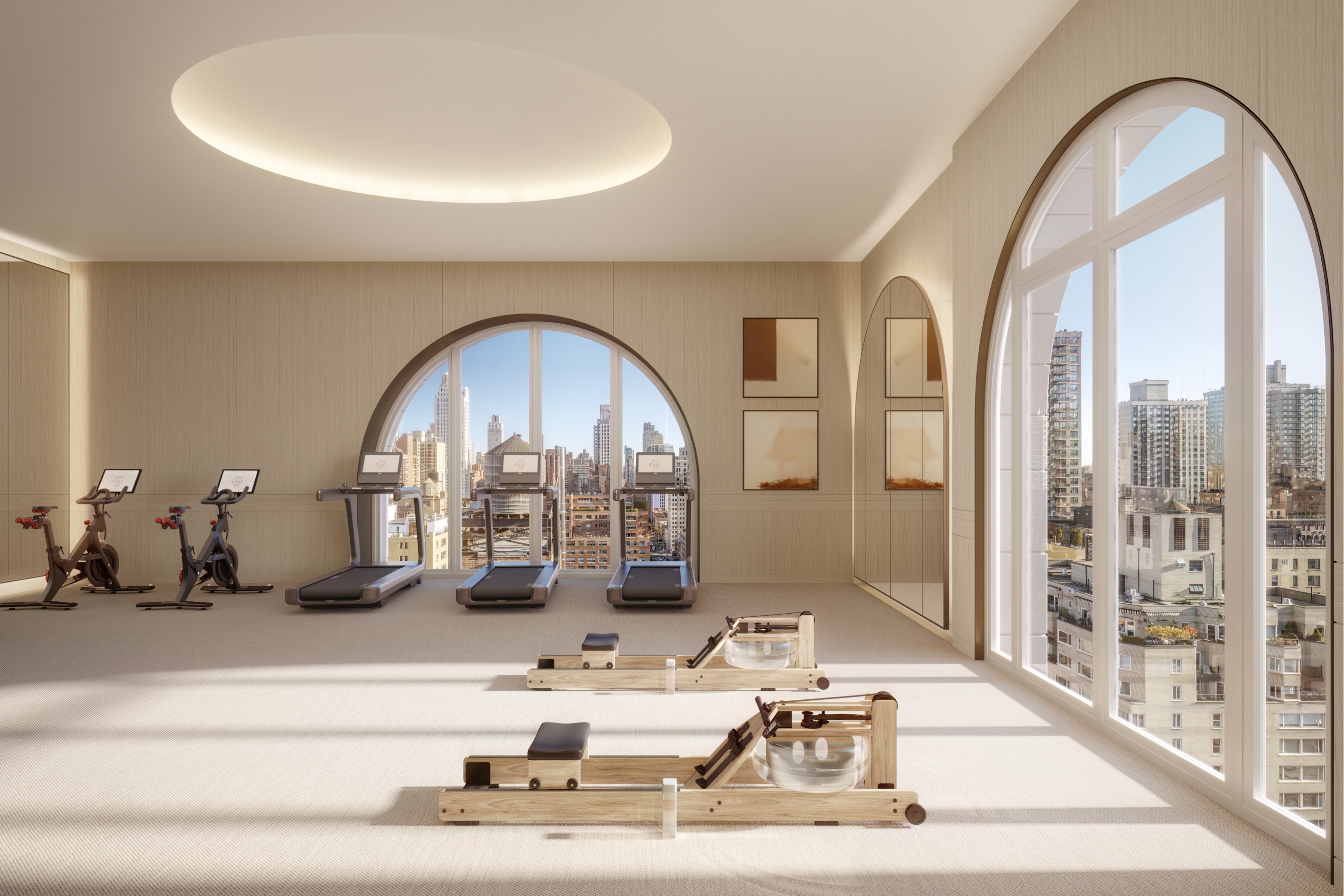 Well-equipped fitness room overlooking the city, showcasing amenities at 255 East 77, Upper East Side condominiums.